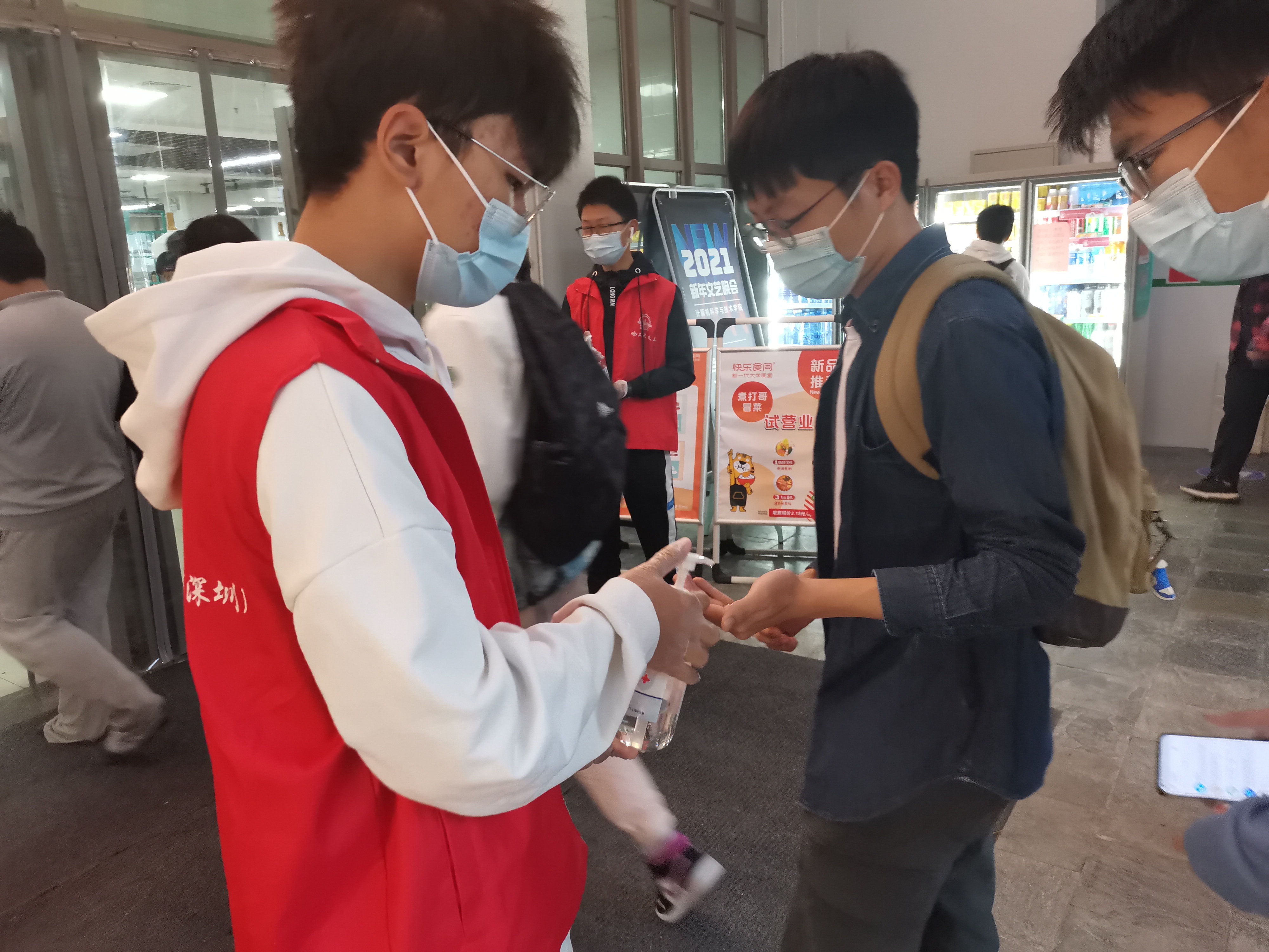 1614906694417058018.jpg 志愿者在食堂门口为师生消毒3.jpg